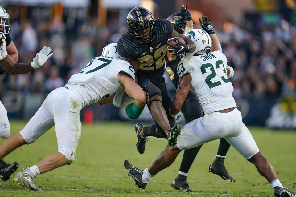 Purdue running back King Doerue (22) leaps between Michigan State linebacker Cal Haladay (27) and safety Darius Snow (23) during the second half of an NCAA college football game in West Lafayette, Ind., Saturday, Nov. 6, 2021. Purdue won 40-29. (AP Photo/Michael Conroy)