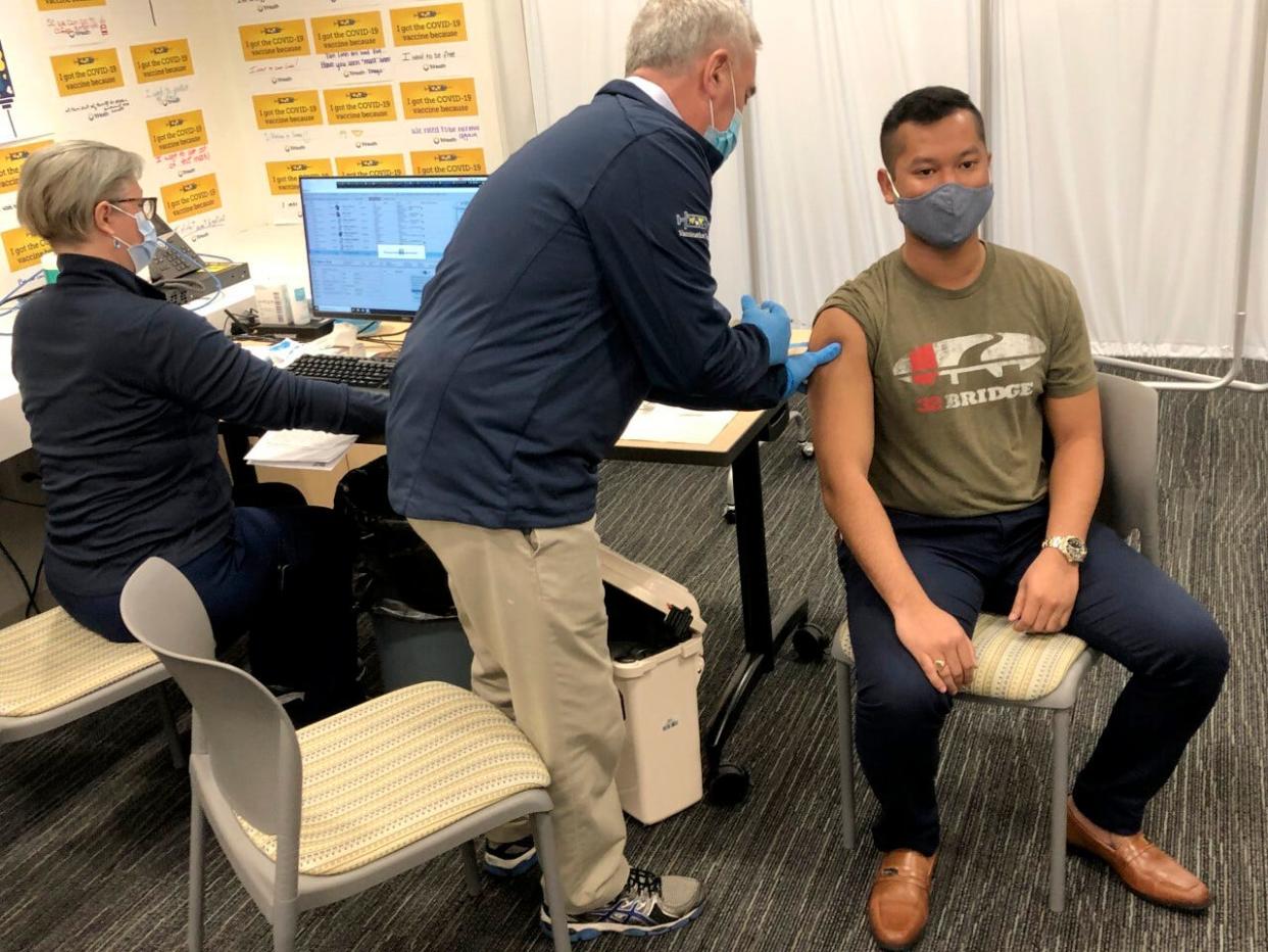 U.S. Rep. Brad Wenstrup administers a COVID-19 vaccine to Eli Livingston with the aid of a doctor, left, in Norwood, Ohio, on March 28, 2021.