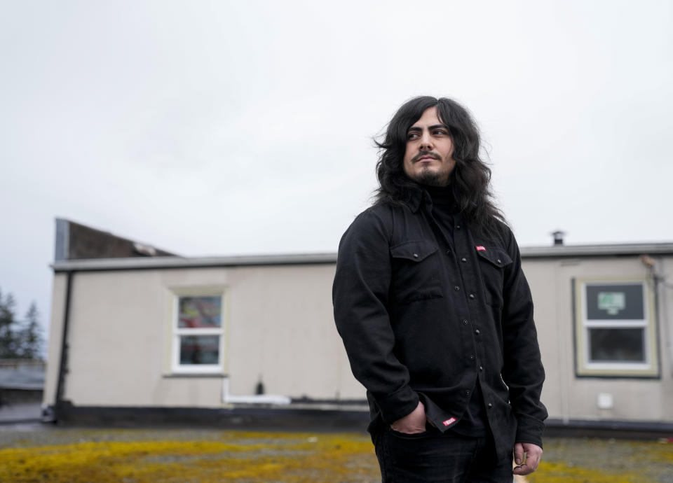 CORRECTS TO TWO SEMESTERS, NOT ONE - Santos Enrique Camara, who dropped out of Shoreline Community College at age 19 in 2015 after completing two semesters studying audio engineering, poses for a portrait outside his home Friday, March 24, 2023, in Marysville, Wash. Camara, now 27, had difficulty paying tuition and finding time to do schoolwork while caring for his younger sister. "I seriously tried," he said. "I gave it my all." For now, Camara is happy working as a sous-chef and cook at a local restaurant while planning a tour with one of his two bands. (AP Photo/Lindsey Wasson)