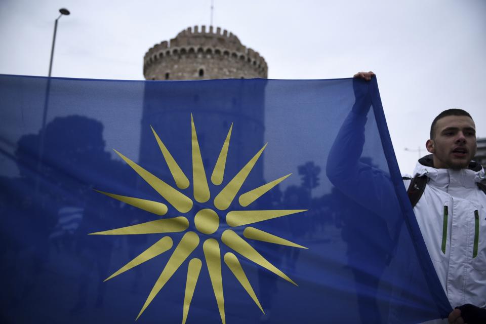 A teenager holds, a flag with the Star of Vergina, the emblem of the ancient Greek kingdom of Macedonia, during a protest in front of the White Tower, a landmark of the northern Greek city of Thessaloniki, Thursday, Nov. 29, 2018. About 1,000 high school students protested against government efforts to end a three-decade-old dispute with neighboring Macedonia. (AP Photo/Giannis Papanikos)