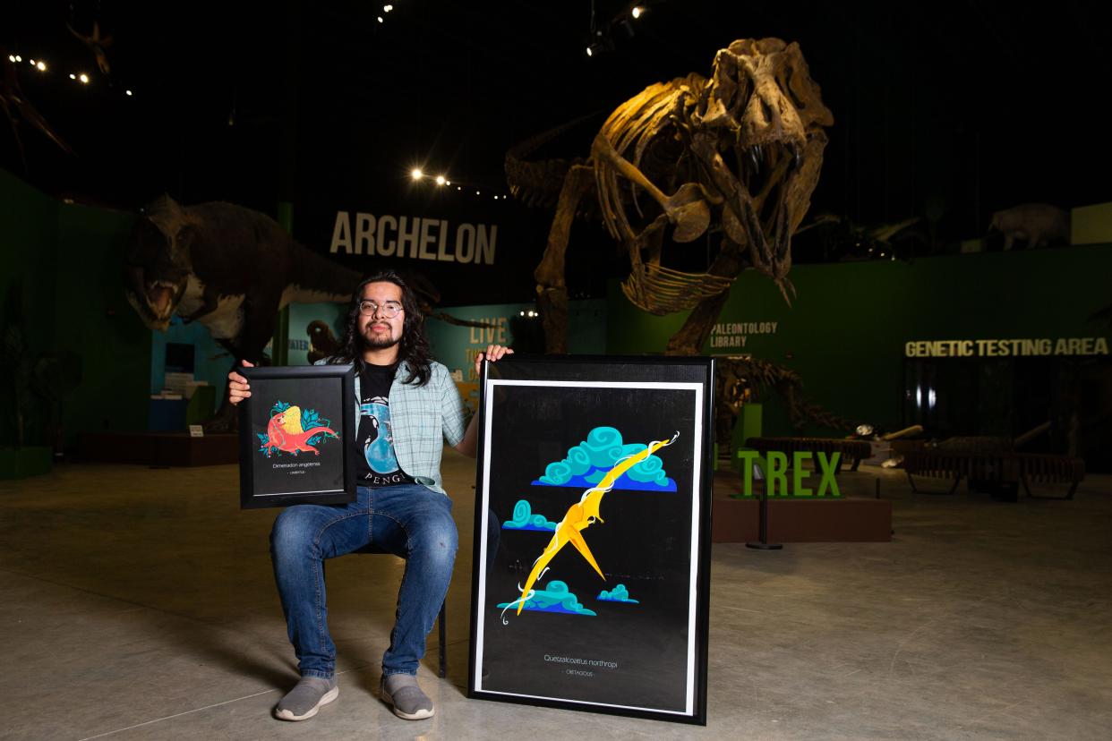 Alfredo Siqueiros-Gonzalez poses for a photo while holding up prints of his art pieces at the Indiana Dinosaur Museum on Monday, June 17, 2024, in South Bend.