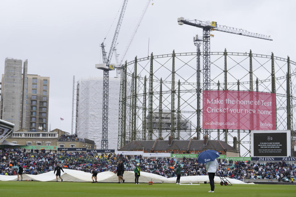 Rain covers are brought onto the pitch as rain stops play on day four of the fifth Ashes Test match between England and Australia, at The Oval cricket ground in London, Sunday, July 30, 2023. (AP Photo/Kirsty Wigglesworth)