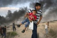 <p>A Palestinian protester carries a boy as he runs from tear gas fired by Israeli soldiers during a protest on the beach near the border with Israel in Beit Lahiya, northern Gaza Strip, Monday, Sept. 10, 2018. Gazaâs Health Ministry says Israeli troops wounded 10 Palestinians during a protest on the enclaveâs northern ground and maritime fence with Israel. (AP Photo/Felipe Dana) </p>