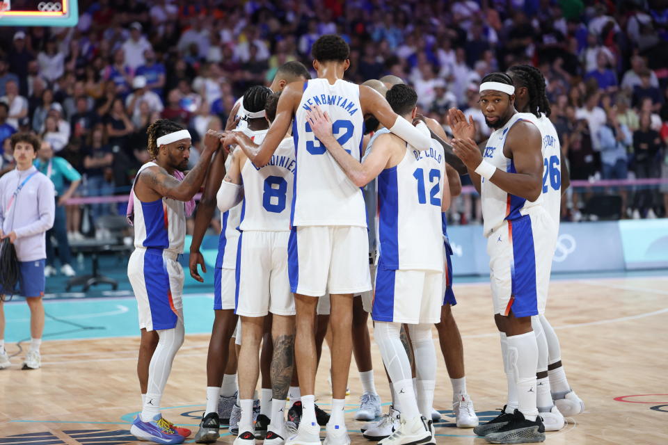 France's #32 Victor Wembanyama (C) and teammates unite at the end of the men's preliminary round group B basketball match between France and Germany during the Paris 2024 Olympic Games at the Pierre-Mauroy stadium in Villeneuve-d'Ascq, northern France, on August 2, 2024. (Photo by Thomas COEX / AFP) (Photo by THOMAS COEX/AFP via Getty Images)