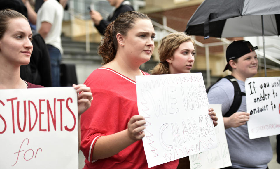 Elizabeth Brooks, a junior in politics and policy holds a sign with other protestors during a student protest Liberty University in Lynchburg, Va., Friday, Sept. 13, 2019. Students at Liberty University gathered to protest in the wake of news articles alleging that school president Jerry Falwell Jr. "presides over a culture of self-dealing” and improperly benefited from the institution. Falwell Jr. told The Associated Press on Tuesday that he wants the FBI to investigate what he called a "criminal" smear campaign orchestrated against him by several disgruntled former board members and employees. (Taylor Irby/The News & Advance via AP)