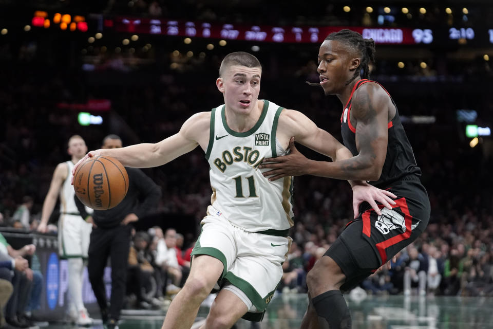 Boston Celtics guard Payton Pritchard (11) drives toward the basket in front of Chicago Bulls guard Ayo Dosunmu, right, in the second half of an NBA In-Season Tournament basketball game, Tuesday, Nov. 28, 2023, in Boston. (AP Photo/Steven Senne)