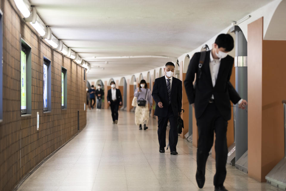 People wearing face masks walk through an underpass tunnel in Tokyo on Thursday, May 13, 2021. The Japanese capital confirmed more than 1,000 new coronavirus cases on Thursday. (AP Photo/Hiro Komae)