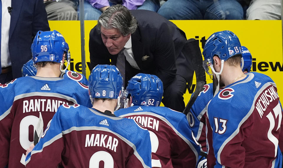 Colorado Avalanche coach Jared Bednar confers with players during a timeout in the third period of Game 3 of the team's NHL hockey Stanley Cup playoff series against the Dallas Stars on Saturday, May 11, 2024, in Denver. (AP Photo/David Zalubowski)