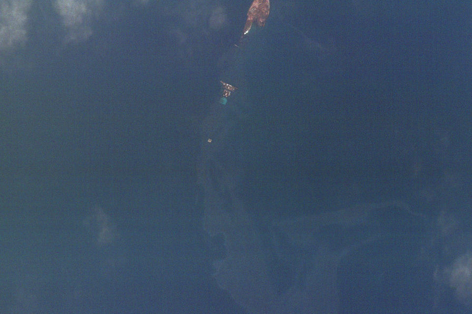 This satellite image from Planet Labs shows an oil spill drifting from the wreckage of the Trinity Spirit ship, top center, on Feb. 7, 2022, following an explosion aboard the ship. The ship was used to store and refine large quantities of oil extracted from the ocean floor and moored 15 miles off the coast of Nigeria. The vessel was carrying 40,000 barrels of oil. (Planet Labs via AP)