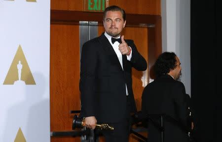 Leonardo DiCaprio, Best Actor winner for his role in "The Revenant," and Best Director winner Alejandro G. Inarritu (R), also for "The Revenant," carry their Oscars together backstage at the 88th Academy Awards in Hollywood, California February 28, 2016. REUTERS/Mike Blake