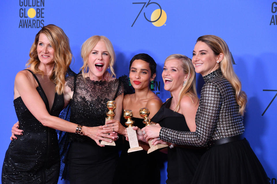 The five costars smiling and holding awards