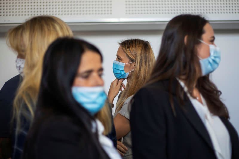 Israeli model Bar Refaeli wears a face mask amid the coronavirus disease (COVID-19) pandemic as she flanked by her lawyers and her mother inside a courtroom in Tel Aviv