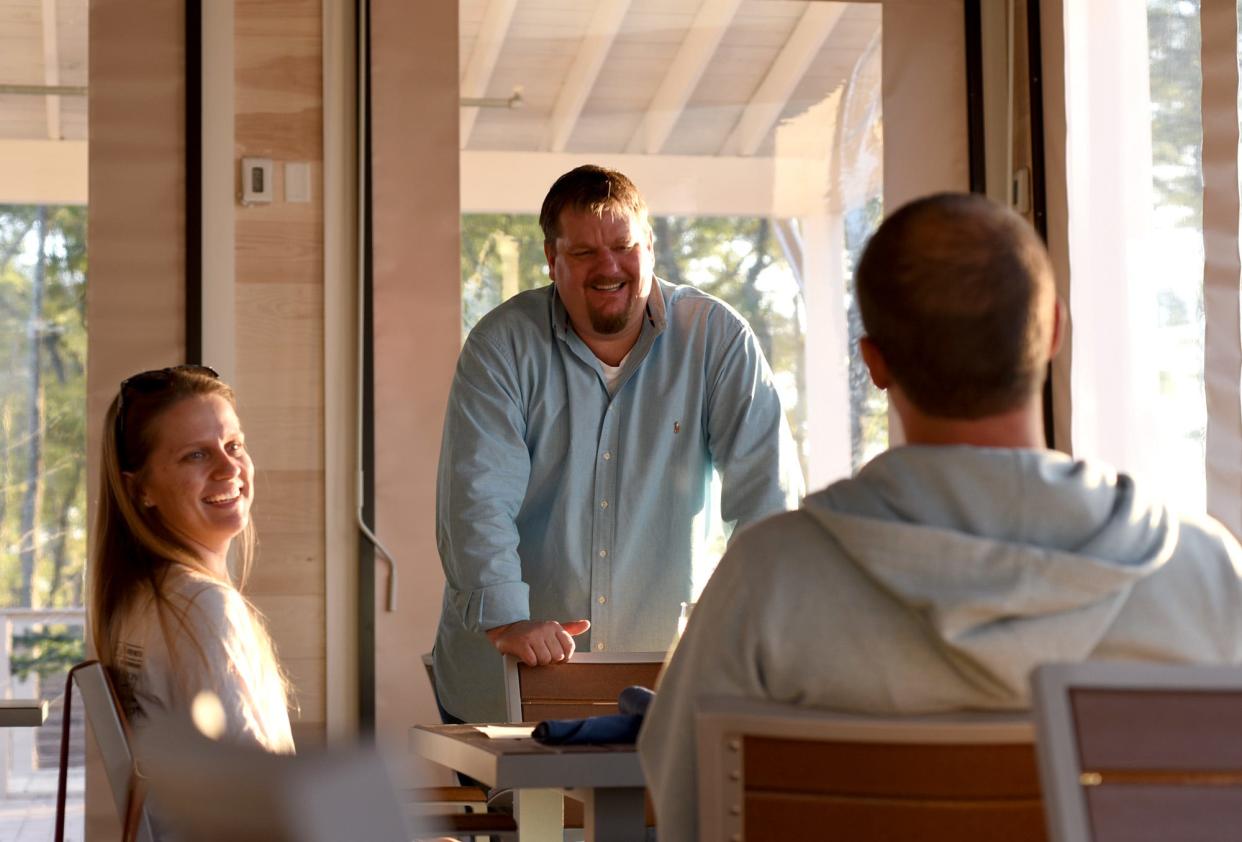 James Smith talks to diners at Smoke on the Water at 3704 Watercraft Ferry Drive in the RiverLights development. STARNEWS FILE PHOTO