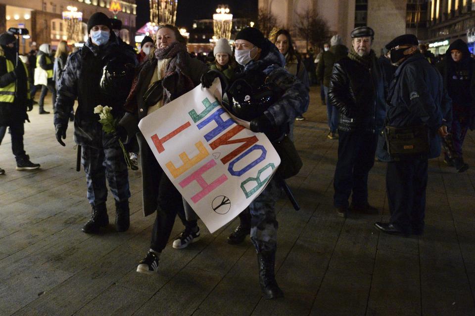 Police officer detain a demonstrator with the poster reading "No war" during an action against Russia's attack on Ukraine in Moscow, Russia, Thursday, Feb. 24, 2022. Hundreds of people gathered in the center of Moscow and St. Petersburg on Thursday, protesting against Russia's attack on Ukraine. Many of the demonstrators were detained. Similar protests took place in other Russian cities, and activists were also arrested. (AP Photo/Denis Kaminev)