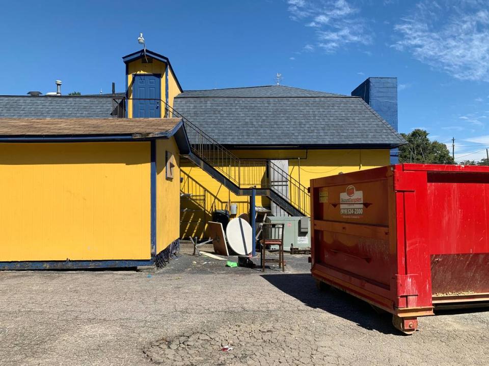 Tables and chairs are piled behind Toot-n-Tell, near a dumpster, on Sept. 27, 2021.