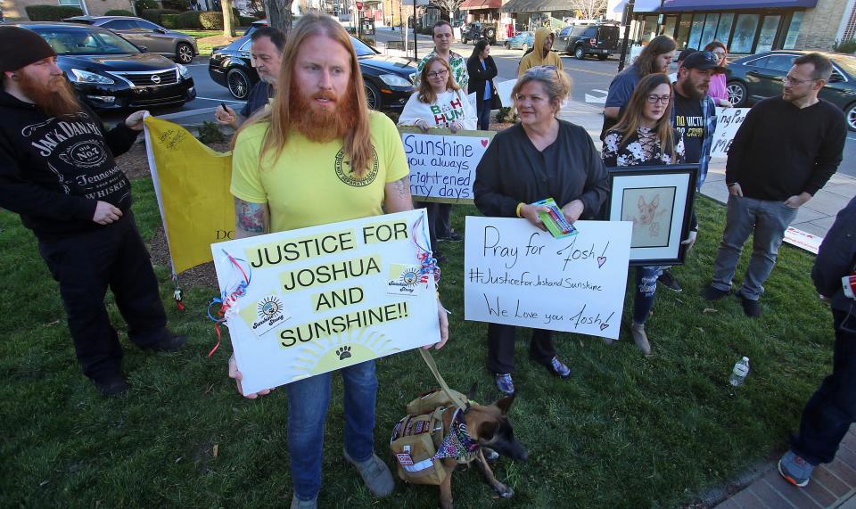 Joshua Rohrer holds a sign as he and others attend the Rally for Justice and Compassion in front of Gastonia City Hall Tuesday evening, March 1, 2022. 