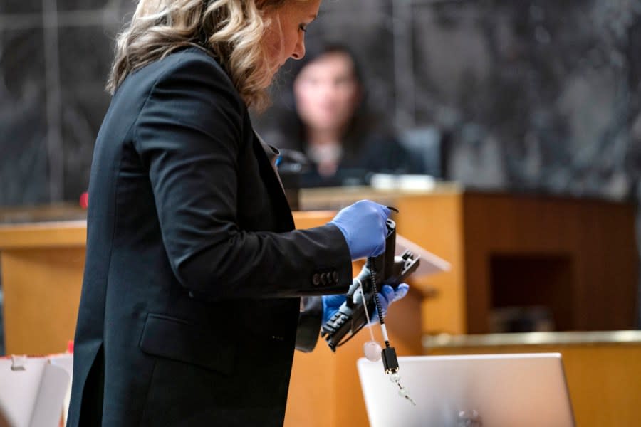 Oakland County Prosecutor Karen McDonald demonstrates how swiftly she was able to insert a gun lock during closing statements in the trial of James Crumbley, Wednesday, March, 13, 2024 in Pontiac, Mich. Crumbley is charged with involuntary manslaughter, accused of failing to secure a gun at home and ignoring his son’s mental health. Ethan Crumbley killed four students at Oxford High School in 2021. (Mandi Wright/Detroit Free Press via AP, Pool)