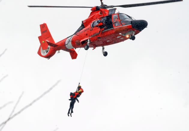 A U.S. Coast Guard diver pulls a body from a submerged vehicle stuck in rushing rapids just yards from the brink of Niagara Falls.  (Photo: Sharon Cantillon via AP)