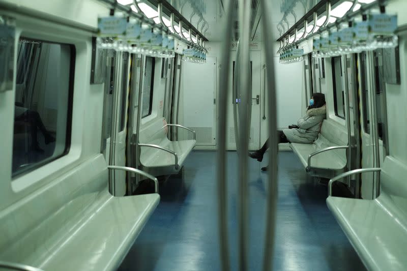 A woman wearing a face mask travels in the subway, as the country is hit by an outbreak of the new coronavirus, in Beijing