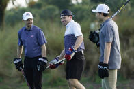 Columbus Blue Jackets left wing Johnny Gaudreau, left, Nick Suzuki, of the Montreal Canadiens, and Dallas Star left wing Jason Robertson, right, talk on the green before putting with their hockey sticks on a golf skills competition, Wednesday, Feb. 1, 2023, in Plantation, Fla. The event was part of the NHL All Star weekend. (AP Photo/Marta Lavandier)