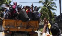 Residents ride a truck on the way to an evacuation center after they were forced to evacuate their village due to fighting between government soldiers and Muslim rebels from the Moro National Liberation Front (MNLF), in Zamboanga city in southern Philippines September 13, 2013. Local government officials said evacuees have reached to about 20,000 people, as a government stand-off with the MNLF seeking an independent state reaches its fifth day. REUTERS/Erik De Castro (PHILIPPINES - Tags: CIVIL UNREST CONFLICT POLITICS)