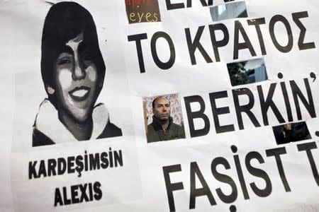 A protester in seen through a banner depicting late Turkish Berkin Elvan during a rally in solidarity to the anti-government protesters in Turkey, in Athens March 13,2014. REUTERS/Alkis Konstantinidis