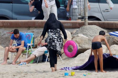 A Muslim woman wears a burkini, a swimsuit that leaves only the face, hands and feet exposed, on a beach in Marseille, France, August 17, 2016. REUTERS/Stringer/File Photo