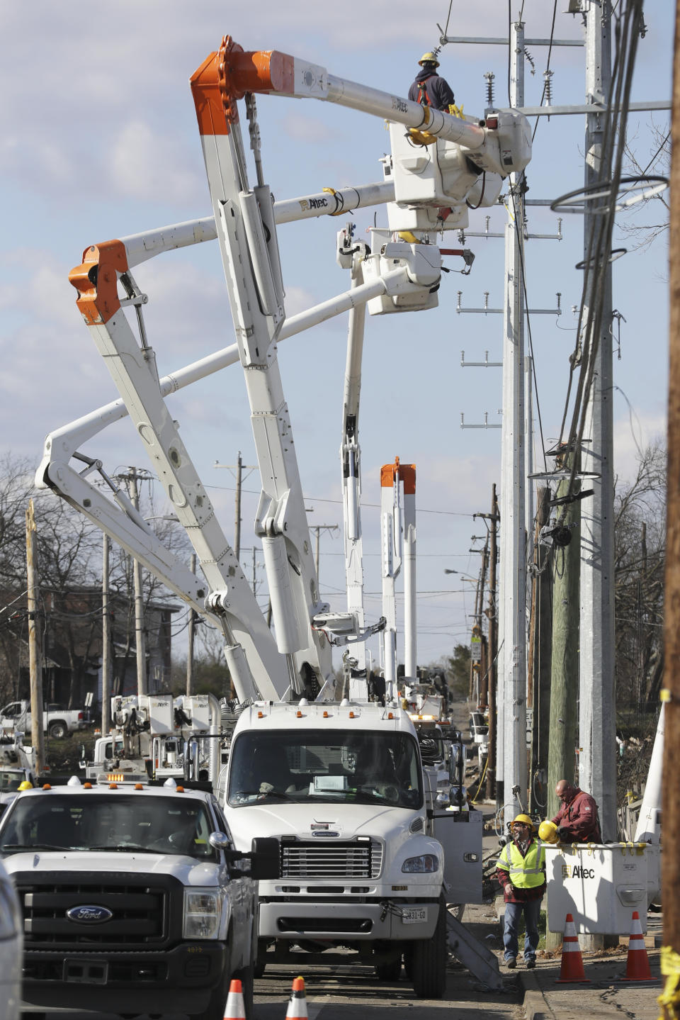 Workers repair power lines Friday, March 6, 2020, in Nashville, Tenn. Utility companies, residents and businesses face a huge cleanup effort after tornadoes hit the state Tuesday. (AP Photo/Mark Humphrey)