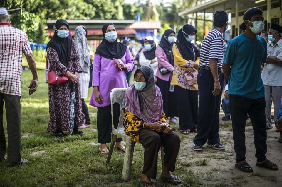 Voters wearing protective masks queue up to cast their votes during the Sabah state election in SK Pulau Gaya September 26, 2020. — Picture by Firdaus Latif