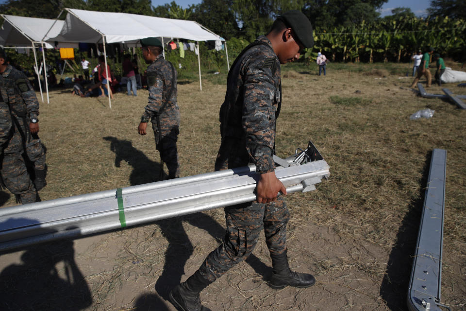 Guatemalan soldiers build a tent for Honduran migrants at a temporary shelter in Tecun Uman, Guatemala in the border with Mexico, Sunday, Jan. 19, 2020. Mexican authorities have closed a border entry point in southern Mexico after thousands of Central American migrants tried to push across a bridge between Mexico and Guatemala. (AP Photo/Moises Castillo)