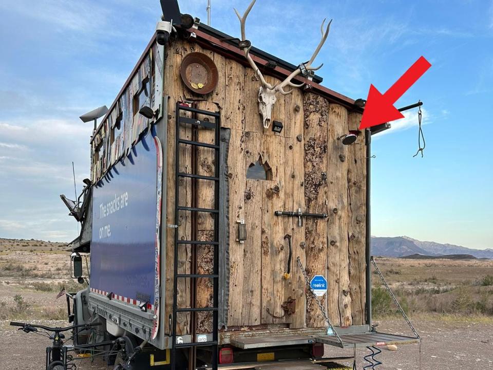 A red arrow pointing at the outdoor shower head.