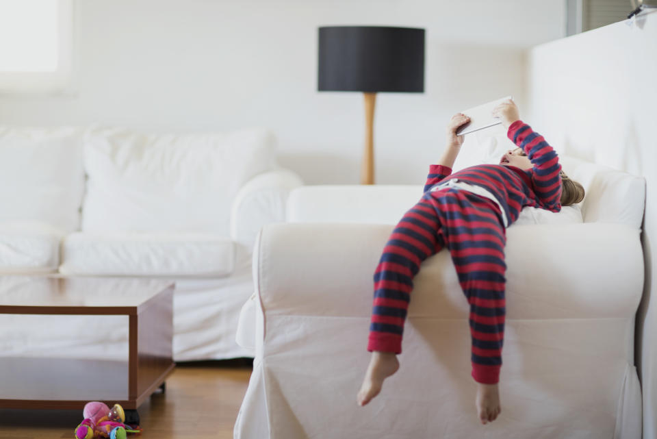 little boy lying on a couch on a tablet to recover from a concussion