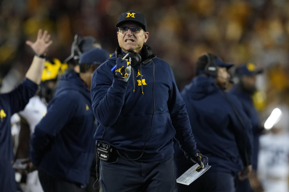 FILE - Michigan head coach Jim Harbaugh gestures toward a referee during the first half of an NCAA college football game against Minnesota Saturday, Oct. 7, 2023, in Minneapolis. The NCAA banned in-person advanced scouting in 1994 in part because not every school could afford to do it. Now Michigan is being investigated by the NCAA for a sign-stealing scheme that allegedly involved people secretly being sent to record opponents’ games. No. 2 Michigan and the Big Ten acknowledged the investigation Thursday, Oct. 19, 2023. (AP Photo/Abbie Parr, File)