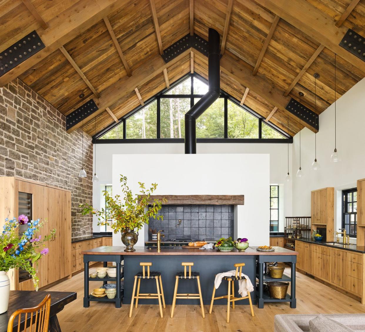 a rustic farmhouse kitchen with a large island and a stone wall