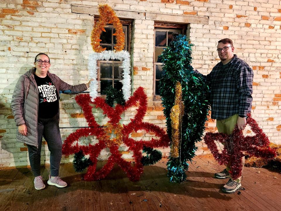 Christmas in Hanover committee members Justine Trucksess, left, and Christopher Arter, right, pose for a photo with the new(left) and old(right) downtown Hanover Christmas decorations.