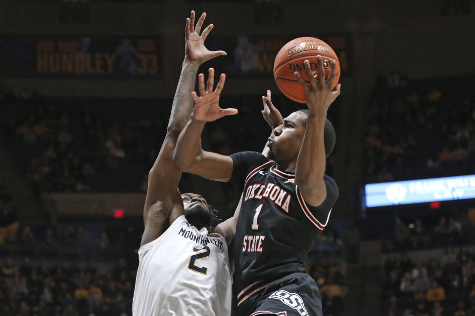 Oklahoma State guard Bryce Thompson (1) is defended by West Virginia guard Kobe Johnson (2) during the first half of an NCAA college basketball game on Monday, Feb. 20, 2023, in Morgantown, W.Va. (AP Photo/Kathleen Batten)