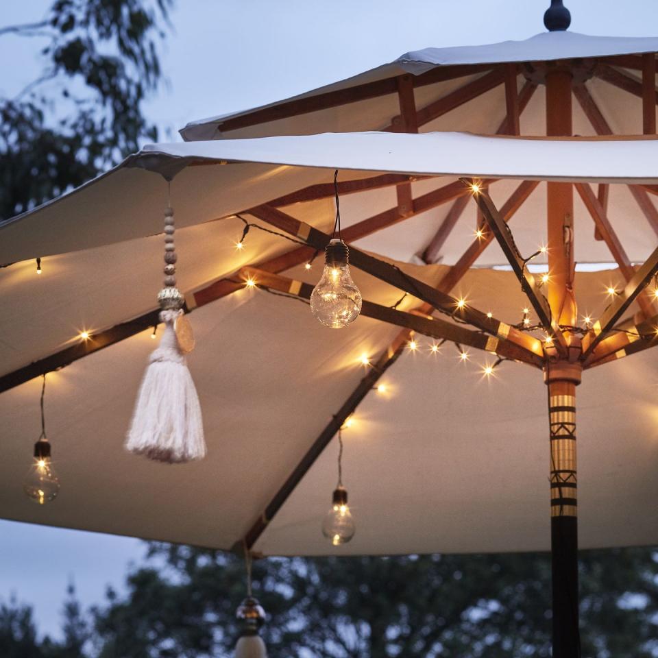 <p>Outdoor lights offer a quick, simple and cheap way to bring a pretty glow to a patio and beyond – and there are so many styles available. Solar garden lights are popular, or you can opt for outdoor battery lights which include string lights and lanterns.</p><p>If you're using fairy lights or festoon lights, you can style them through trees or shrub branches, attach them to <a href="http://www.housebeautiful.co.uk/garden/designs/a793/fencing-guide/" rel="nofollow noopener" target="_blank" data-ylk="slk:fences;elm:context_link;itc:0;sec:content-canvas" class="link ">fences</a> and <a href="https://www.housebeautiful.com/uk/garden/g21058049/outdoor-garden-furniture-sets/" rel="nofollow noopener" target="_blank" data-ylk="slk:furniture;elm:context_link;itc:0;sec:content-canvas" class="link ">furniture</a>, or suspend them from canes stuck into the ground. Stringing fairy lights across a pergola or arch or even around a parasol, always looks wonderful and creates a perfect setting for alfresco dining.</p><p><strong>Pictured: </strong>80 LED Battery Operated Parasol Lights, <a href="https://go.redirectingat.com?id=127X1599956&url=https%3A%2F%2Fwww.lights4fun.co.uk%2Fproducts%2F80-led-battery-operated-parasol-lights&sref=https%3A%2F%2Fwww.housebeautiful.com%2Fuk%2Fgarden%2Fdesigns%2Fg28%2Fgarden-ideas-on-a-budget%2F" rel="nofollow noopener" target="_blank" data-ylk="slk:Lights4Fun;elm:context_link;itc:0;sec:content-canvas" class="link ">Lights4Fun</a></p>