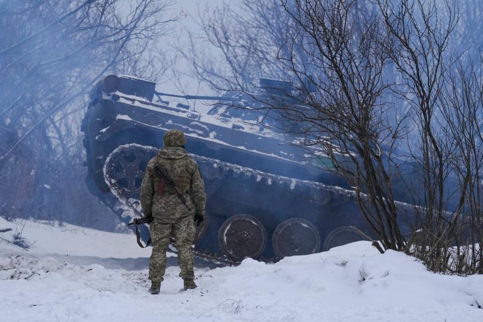 An Ukrainian service member next to an armoured personnel carrier in the Luhansk area (AP)