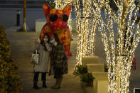 Visitors to a mall pose for photos on New Year Eve in Beijing on Thursday, Dec. 31, 2020. This New Year's Eve is being celebrated like no other, with pandemic restrictions limiting crowds and many people bidding farewell to a year they'd prefer to forget. (AP Photo/Ng Han Guan)