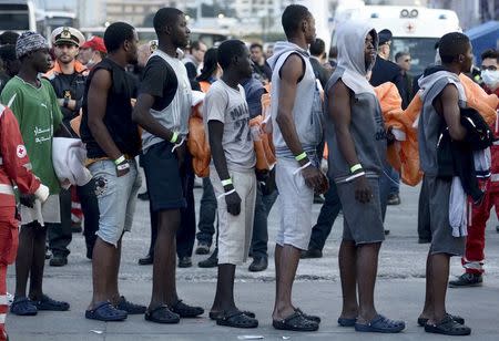 Migrants stand in line after disembarking from the Norwegian vessel Siem Pilot in the Sicilian harbour of Palermo, southern Italy, April 13, 2016. REUTERS/Guglielmo Mangiapane