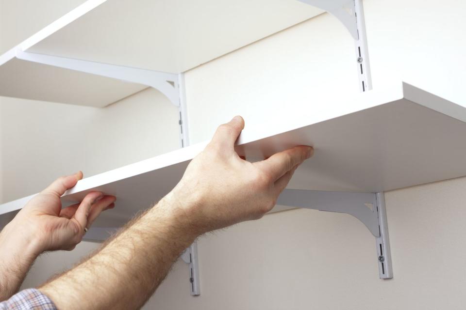 a tradesman installing hanging shelves