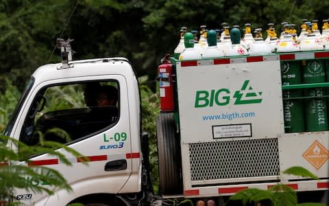 Rescue worker travel on a vehicle loaded with air tanks - Credit: SOE ZEYA TUN /Reuters