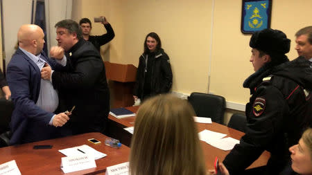 Dmitry Prokhorov (R) a local deputy of the pro-Kremlin United Russia party, pushes opposition deputy Vadim Korovin (L) to prevent him from reaching the seat of the chairman during a session of a Moscow municipal council, in this still image taken from a video in Moscow, Russia November 21, 2017. REUTERS/Maria Tsvetkova