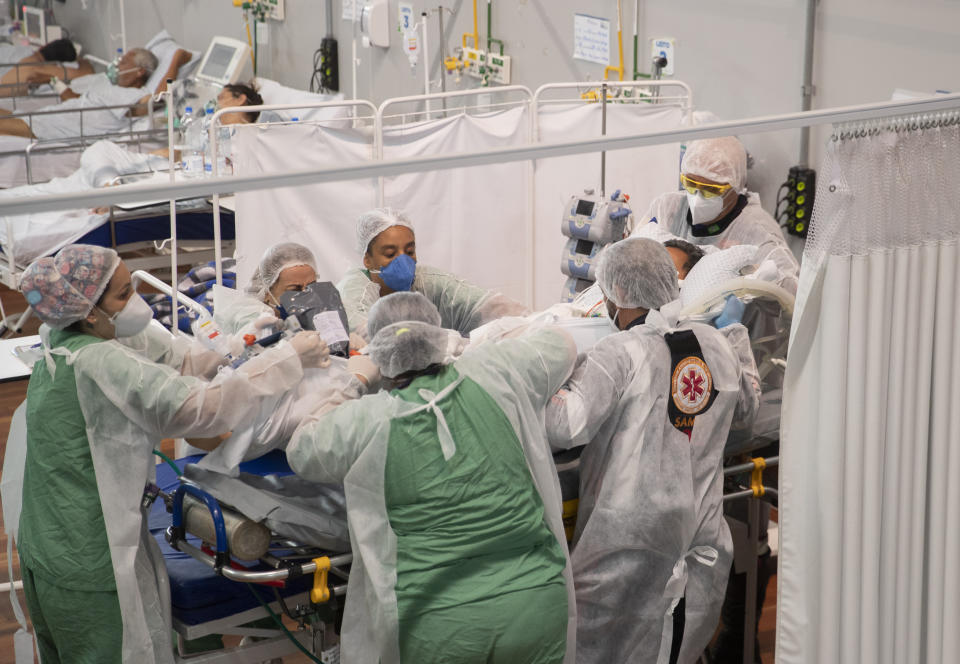 Health workers treat a COVID-19 patient in the ICU of a field hospital built inside a gym in Santo Andre, on the outskirts of Sao Paulo, Brazil, Thursday, March 4, 2021. (AP Photo/Andre Penner)