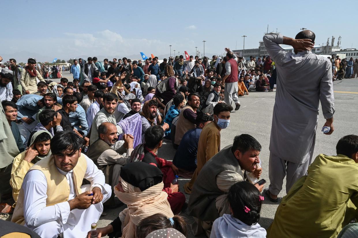 Afghan passengers sit as they wait to leave the Kabul airport in Kabul on Monday, after a stunningly swift end to Afghanistan’s 20-year war. (AFP via Getty Images)