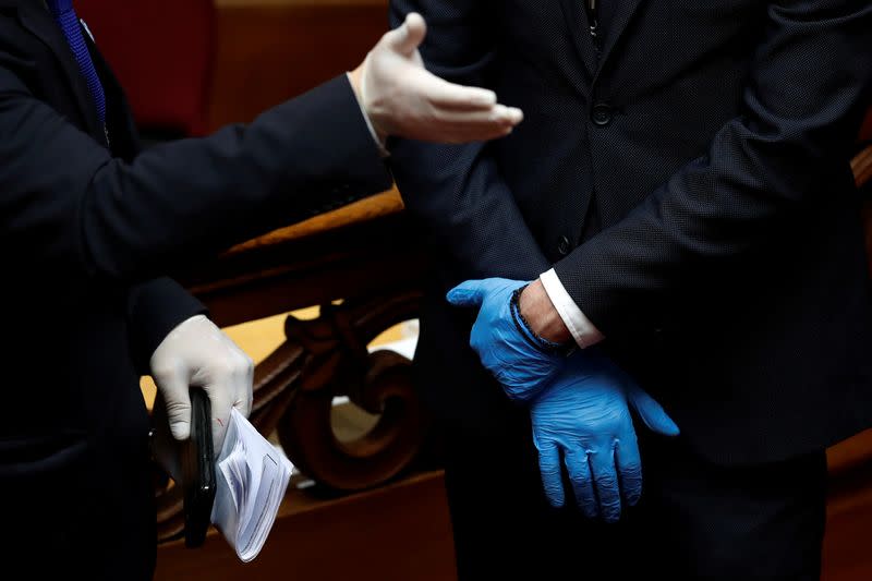 Employees of the Greek Parliament wear gloves ahead of the swearing-in ceremony of the newly elected Greek President Sakellaropoulou in Athens