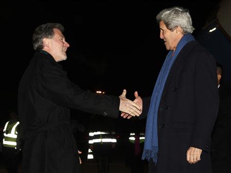 U.S. Secretary of State John Kerry (R) is welcomed by Charge de Affairs Peter Mulrean (L) to Geneva January 21, 2014. REUTERS/Gary Cameron