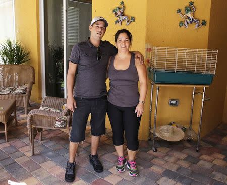 Alain Izquierdo (L), a Havana butcher and one of 15 survivors of the 32 Cuban migrants who were left adrift in Caribbean waters during their voyage, poses with his aunt Amarilis Barrios after speaking with Reuters at his uncle's home in Port St. Lucie, Florida, October 3, 2014. REUTERS/Rickey Rogers