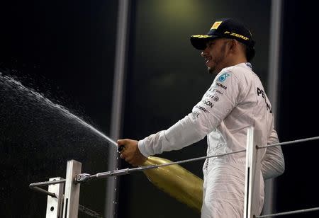 Formula One - F1 - Abu Dhabi Grand Prix - Yas Marina Circuit, Abu Dhabi, United Arab Emirates - 27/11/2016 - Mercedes' Formula One driver Lewis Hamilton of Britain celebrates on the podium. REUTERS/Hamad I Mohammed