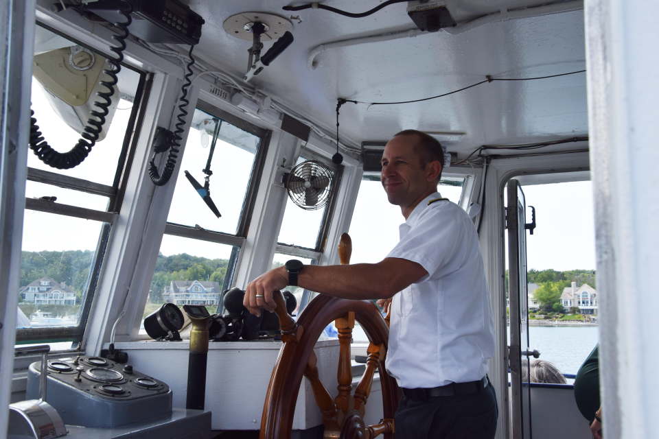 Little Traverse Ferry Company owner Captain Chris Chamberlain steers the ferry during the senior boat ride Aug. 16, 2023.